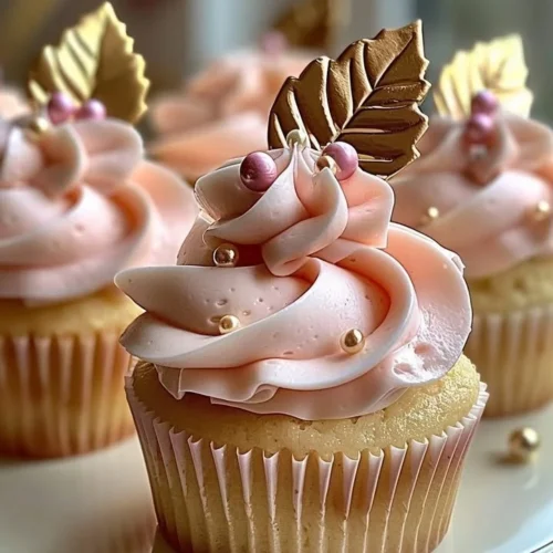 Vanilla cupcakes with blush pink buttercream frosting on a decorated table