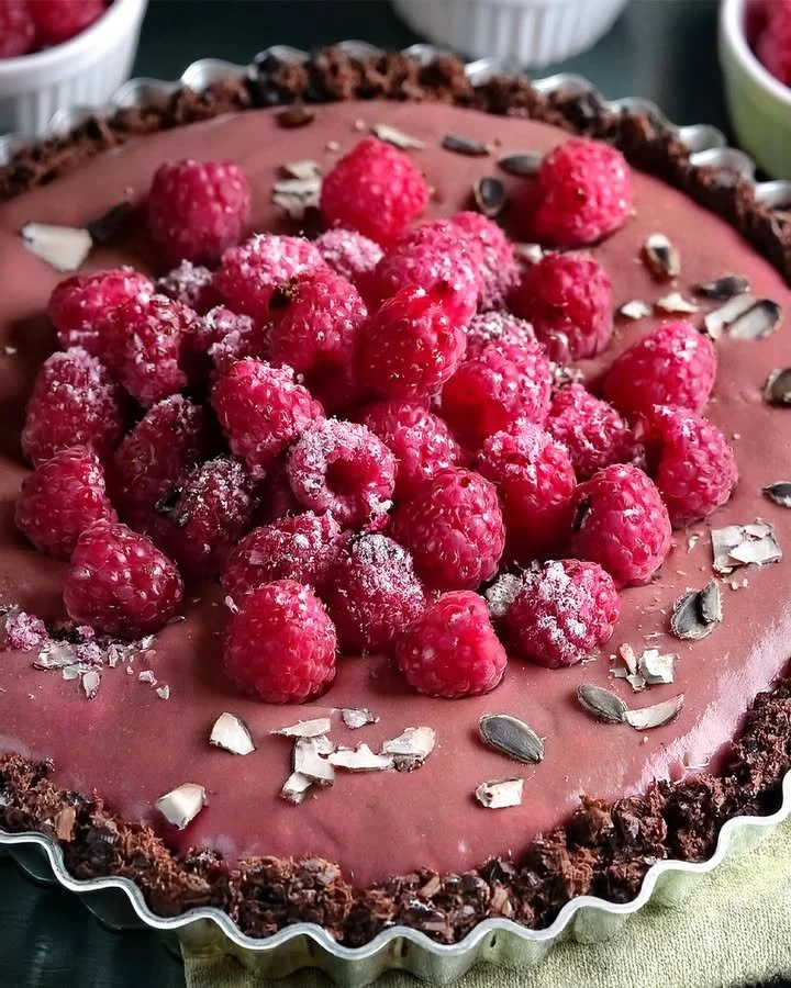 Vegan Raspberry Chocolate Tart topped with fresh raspberries and chocolate drizzle