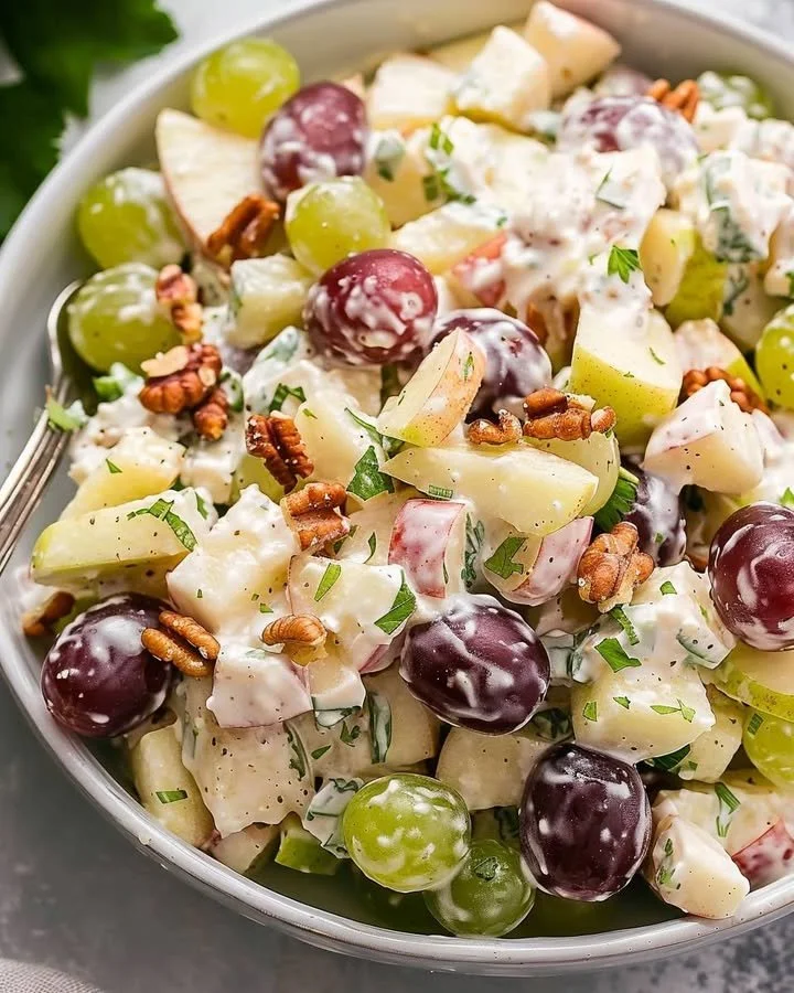 Delicious Waldorf Salad with apples, walnuts, and grapes in a creamy dressing.