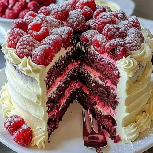 Slice of White Chocolate Raspberry Dream Cake with fresh raspberries on top