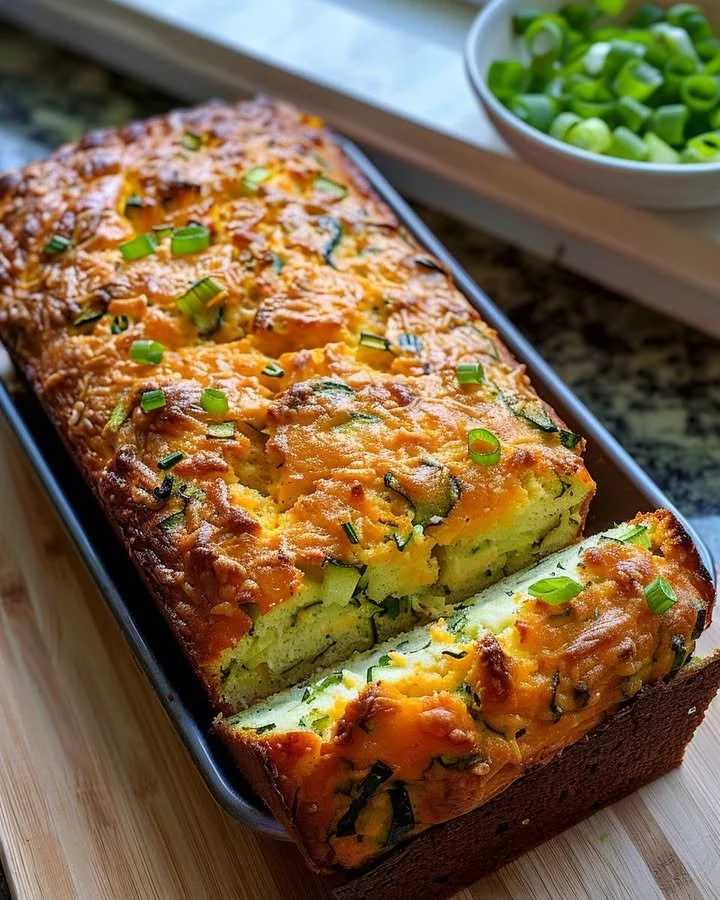 Freshly baked zucchini cheese bread with melted cheese and herbs